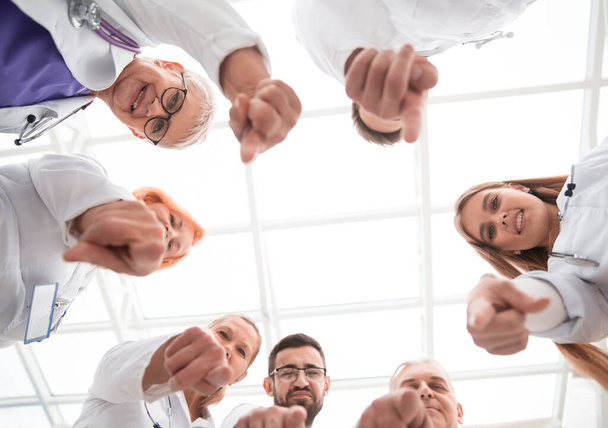 group of doctors standing in a circle and pointing at you . - 写真・画像