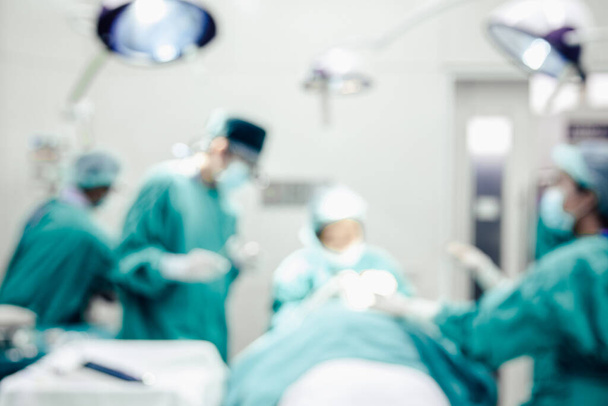 Расплывчатый фон операции хирургов и медсестры, работающих на пациента в операционной в больнице
 - Фото, изображение