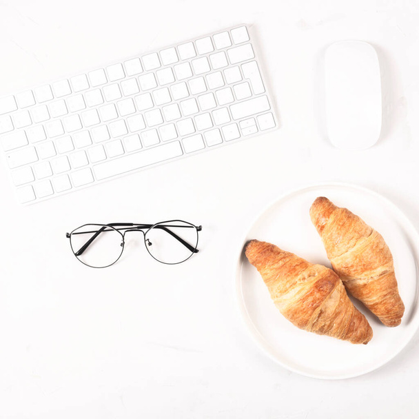 Croissants in a bright workplace as a snack during work - Photo, Image