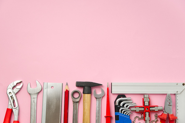 Home maintenance, service, diy concept. Tools for wood, metal and other construction work. Top view on DIY tools. home repairs. on pink background. - Photo, Image