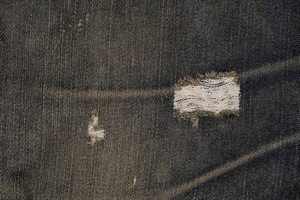 古いジーンズの生地の表面と涙マークのクローズアップ写真、古いジーンズの生地の背景パターン - 写真・画像