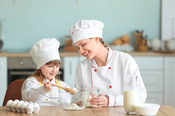 Femmina chef e la sua piccola figlia che cucina in cucina
 - Foto, immagini