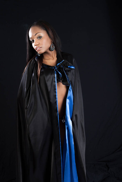 Pensive schwarze Frau in einem schwarz-blauen Umhang - Foto, Bild