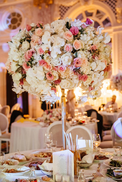 Свадебное оформление в ресторане - сервируется стол с композицией цветов
 - Фото, изображение