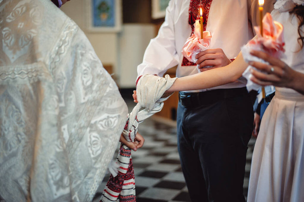 Mãos de noiva e noivo amarrado Toalhas de casamento. O padre amarra a toalha de mão da noiva. mãos de jovens casais na igreja. casal de mãos dadas na toalha na cerimônia da igreja. Dia do casamento
 - Foto, Imagem