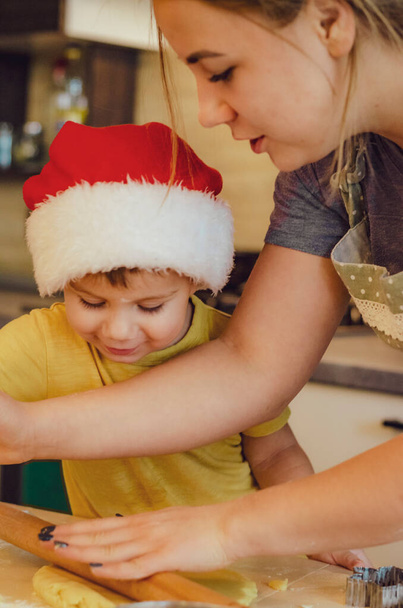 happy funny blonde mother and child baby boy bake christmas cookies.  - 写真・画像