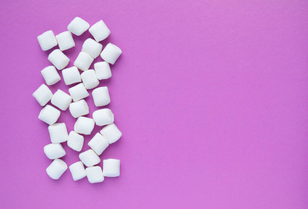 Marshmallows on pink background with copyspace. Flat lay or top view. Background or texture of colorful mini marshmallows. Winter food background concept. - Photo, Image
