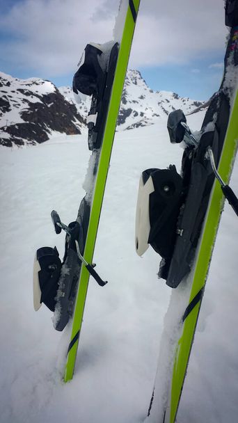 zelené a černé lyže přibité na horu s bílým sněhem - Fotografie, Obrázek