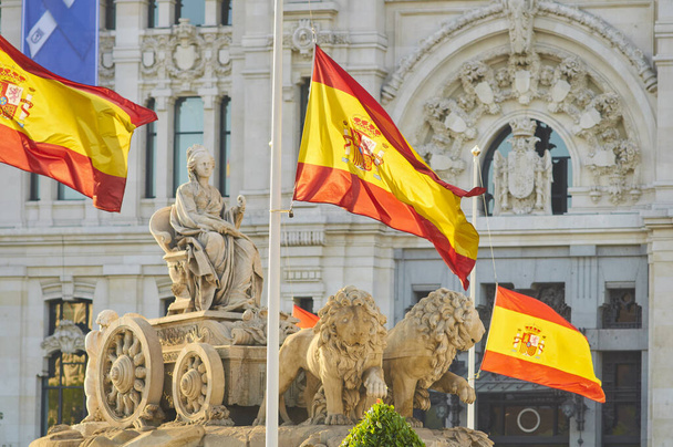 MADRID, İspanya - 26 Mayıs 2020: İspanya, Coronavirus kurbanları için 10 günlük resmi yas ilan etti. Madrid 'in merkezindeki Cibeles heykelinin bayrakları yarıya indirildi. - Fotoğraf, Görsel