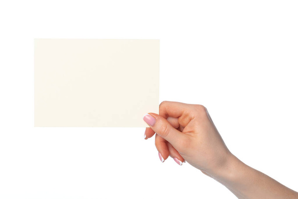 Womans hand holding blank white sheet of paper isolated on white - Photo, Image