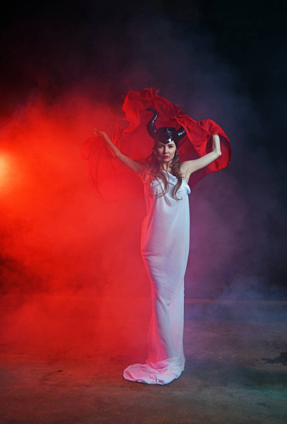 красивая женщина в белом платье богиня земли в дыму танцует с парео под дождем
 - Фото, изображение