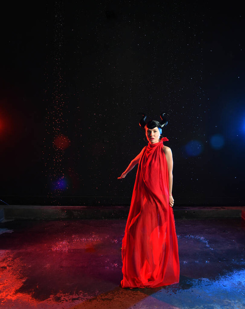beautiful woman in red dress of the goddess of the earth in smoke dancing in the rain - Φωτογραφία, εικόνα