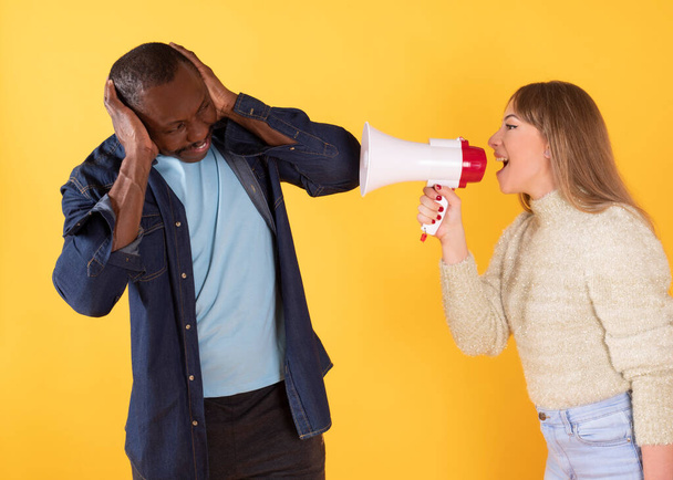 A funny, excited multi-ethnic man and woman screaming into a megaphone - Photo, Image