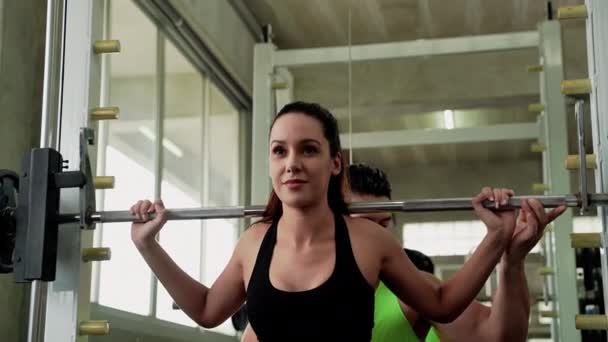 Γυμναστής γυμναστικής διδάσκει όμορφες γυναίκες να ασκούν με την άρση βαρών σωστά στο γυμναστήριο. - Πλάνα, βίντεο