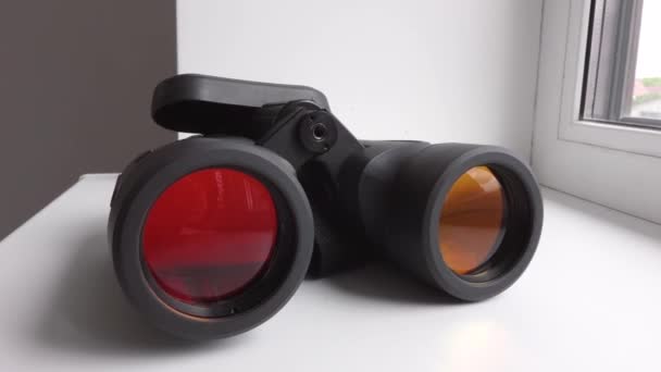 black optical binoculars lie on the white windowsill - Footage, Video