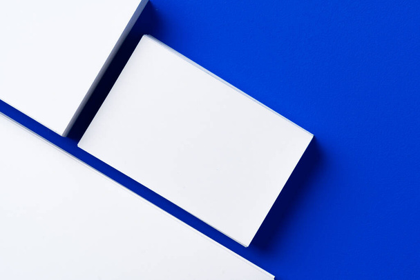 Blank white businesscards on classic blue background - Foto, Imagen