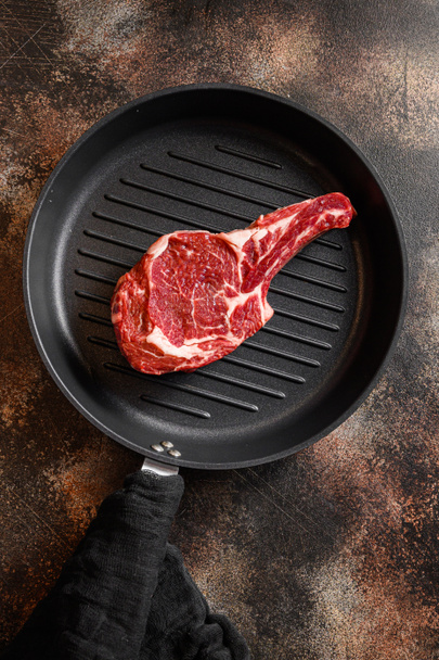 Bone In Steak na patelni grill lub Dallas stek surowy widok z góry. ove rustykalny metal ciemny tło tabeli. - Zdjęcie, obraz