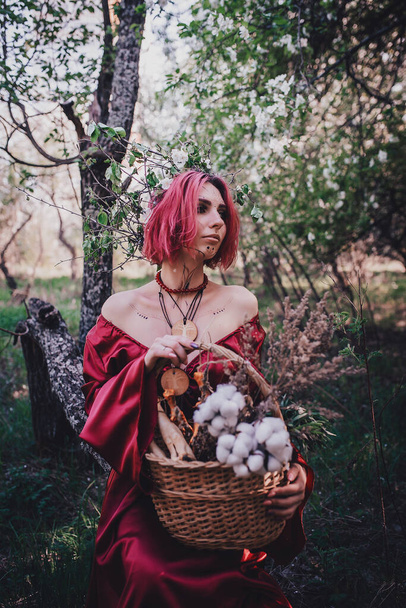 Girl in red and red hair in the form of a druid in apple trees - Zdjęcie, obraz