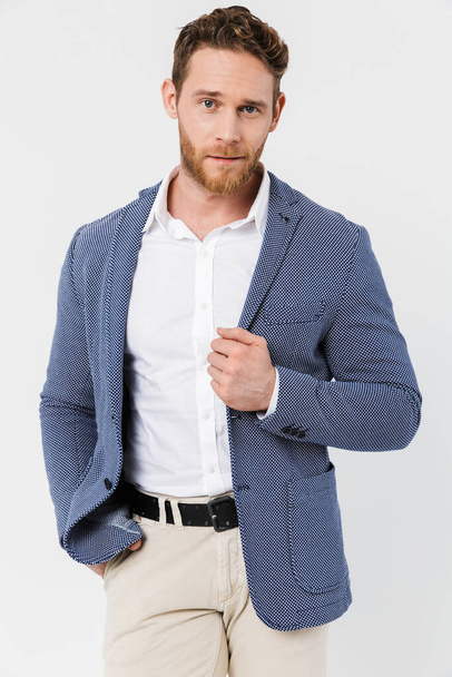 Image of bearded young man wearing jacket posing and looking at camera isolated over white background - Photo, Image