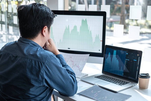 Stock exchange market concept, stock broker looking at graph working and analyzing with display screen, pointing on the data presented and deal on a exchange, Businessman trading stocks online. - Foto, Imagem