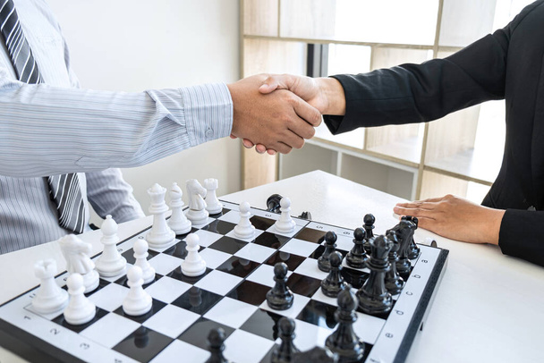 Businessman and businesswoman shaking hands after playing chess and thinking about strategy crash overthrow the opposite team and development analysis for win and successful. - Photo, Image