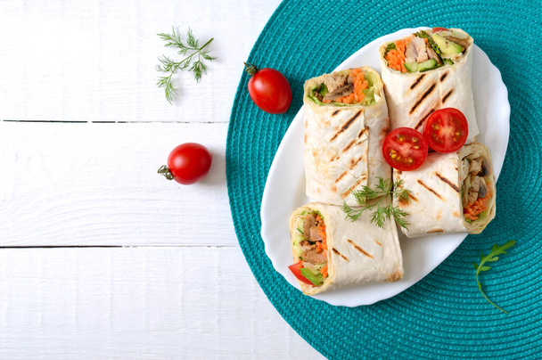 Fresh tortilla wraps with chicken, mushrooms and fresh vegetables. Chicken Mexican burrito. Tasty appetizer. Dishes from pita bread. Healthy food concept - Photo, Image