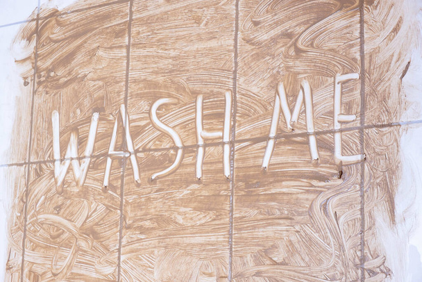 its written on the dirty wall in the bathroom wash me on a white background - Foto, imagen
