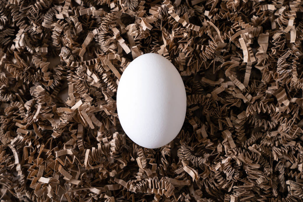 Um ovo de galinha branco no ninho
 - Foto, Imagem