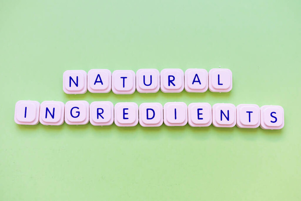 Natural ingredients message made of letter game block over a bright green background. Products made only with natural products - Fotografie, Obrázek
