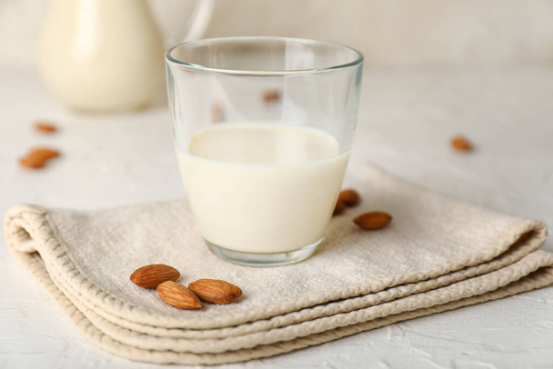 Glass of tasty almond milk on white background - Фото, зображення