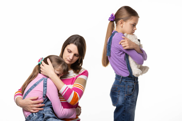 Kinderen ruzie over speelgoed, moeder geruststelt jongere dochter - Foto, afbeelding