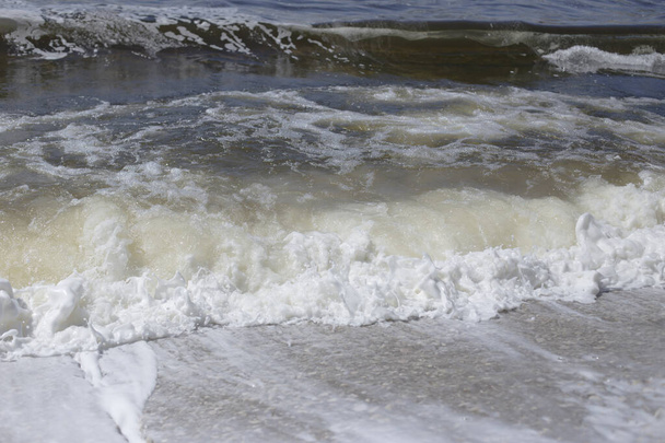 Ποταμός όχθη, καθαρό νερό και λευκό παχύ αφρό από το surf. - Φωτογραφία, εικόνα