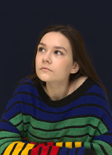 Portrait of a creative young girl looking up while thinking of a new idea or business project against beige background for copy space - Φωτογραφία, εικόνα