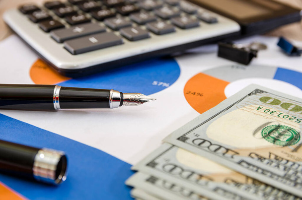 pen on the background of a business graph with a calculator and dollars. Business concept. Close-up. - Photo, image