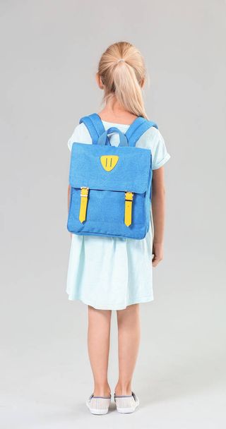 Cute little schoolgirl on color background, back view - Foto, imagen