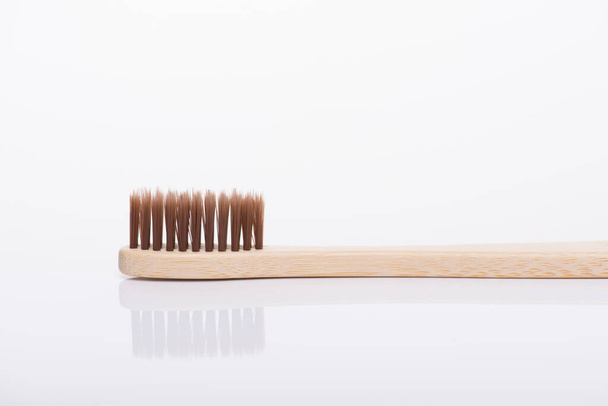 Zero waste concept. Close-up side profile macro view photo of eco-friendly brown toothbrush isolated on white background - Foto, Imagem