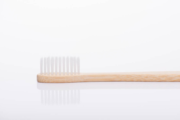 Close-up side profile view photo of eco-friendly white toothbrush isolated on white background - Fotó, kép