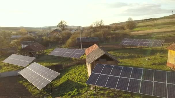 Αεροφωτογραφία πάνω προς τα κάτω των ηλιακών συλλεκτών στην καταπράσινη αυλή του χωριού. - Πλάνα, βίντεο