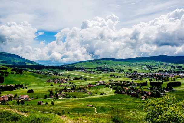 wspaniały widok na góry wokół płaskowyżu Asiago z zielonymi pastwiskami z żółtymi i białymi kwiatami, lasy sosnowe błękitne niebo z białymi chmurami, Vicenza, Wenecja Euganejska, Włochy - Zdjęcie, obraz