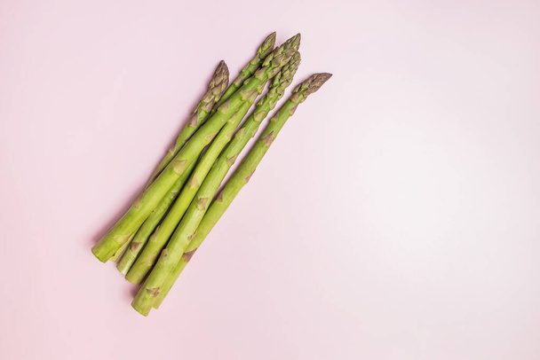 Green seasonal asparagus on a pink background, on a colored background asparagus - Photo, image
