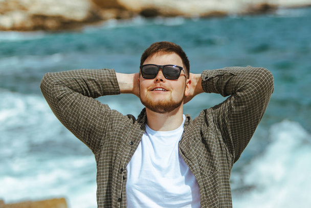 young man in sunglasses with beard portrait at seaside. summer vacation - Photo, Image