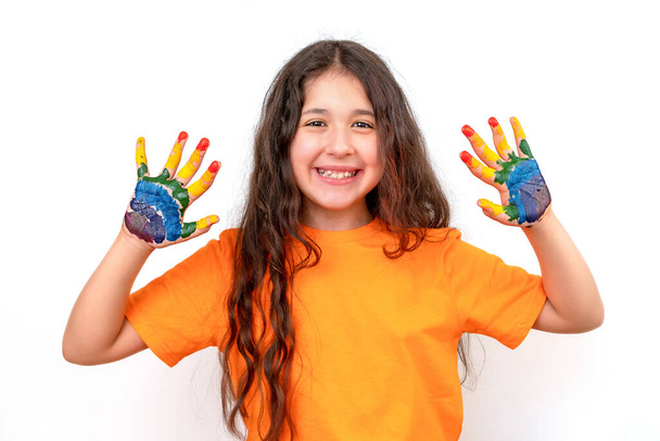 Egy boldog és mosolygós lány portréja sokszínű tenyérrel. Szivárvány a kézen. A boldog gyermekkor és iskolai rajz koncepciója - Fotó, kép