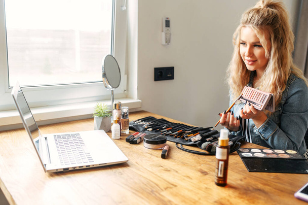 Beautiful woman doing cosmetics review online - Foto, afbeelding