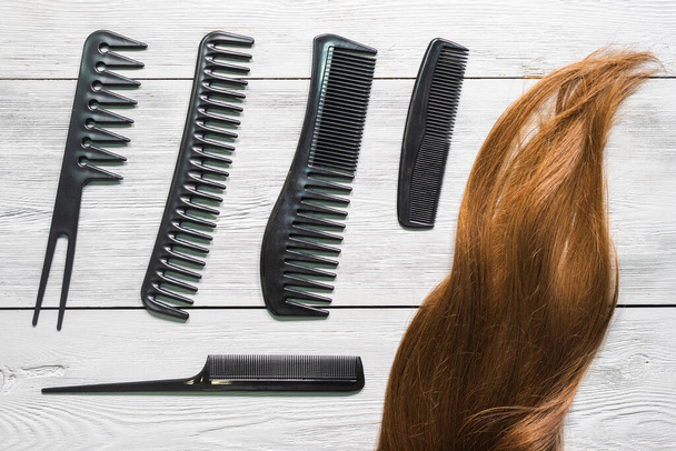 Female hair and a hairbrush on the hairdresser table background. - Foto, Imagen