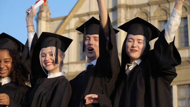 Jovens estudantes de pós-graduação felizes mostrando seus diplomas
. - Foto, Imagem