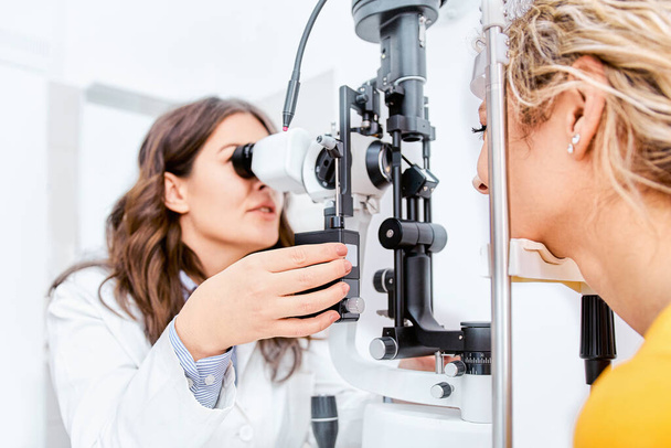 眼科診療所の医師と患者が目の検査、視力検査を行う - 写真・画像