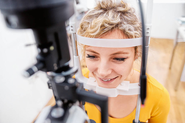Проверка зрения с помощью щелевой лампы, осмотр глаз в офтальмологической клинике
 - Фото, изображение