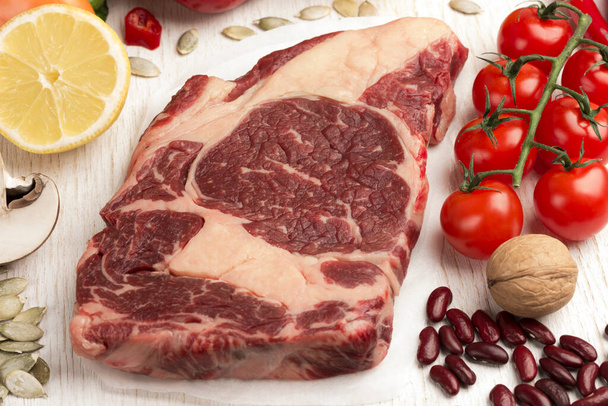 Marbled beef steak with vegetables, beans, nuts on white background. Natural source of protein.  Close up. Top view - Foto, Imagem