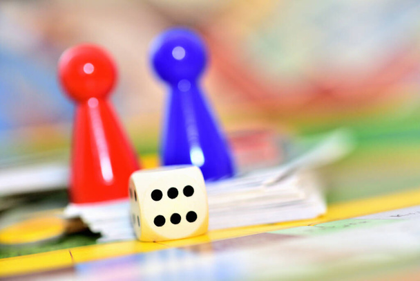 Primer plano de figuras y dados azules, rojos y amarillos en el juego de mesa. - Foto, Imagen