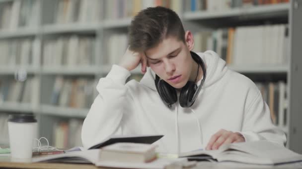 Fatigué gars s'endort tout en se préparant pour l'examen à la bibliothèque de l'école - Séquence, vidéo